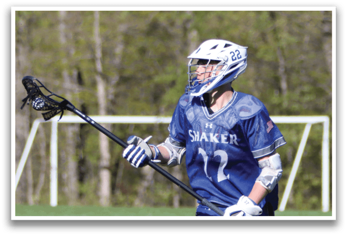 A man wearing a blue and white jersey is holding a black and white lacrosse stick. Description generated by AI