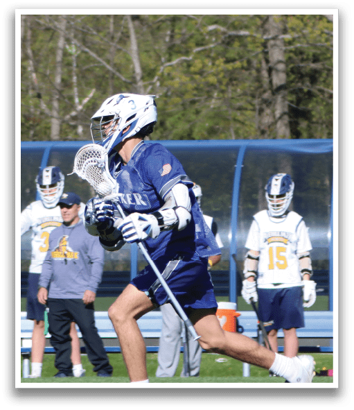 A man running with a lacrosse stick. Description generated by AI