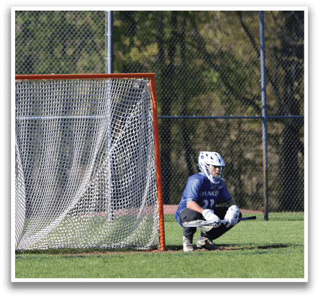 A baseball player is sitting on the ground in front of a net. Description generated by AI