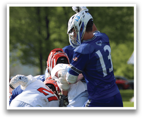 A group of people playing a game of lacrosse. Description generated by AI