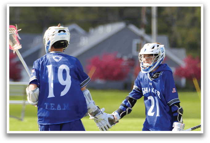 Two young men wearing blue shirts and white gloves shake hands. Description generated by AI