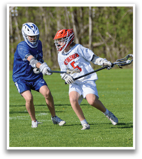 Two boys playing lacrosse on a field. Description generated by AI