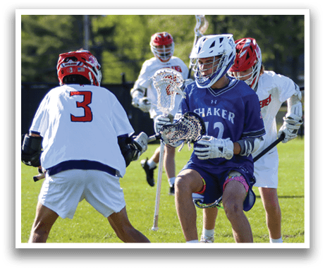 A group of people playing lacrosse on a field. Description generated by AI
