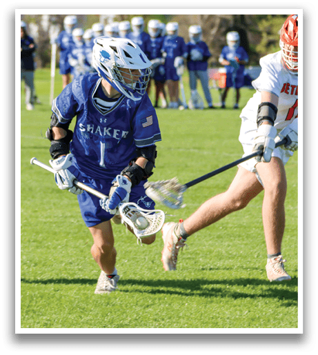 A man in a blue and white uniform is playing lacrosse. Description generated by AI