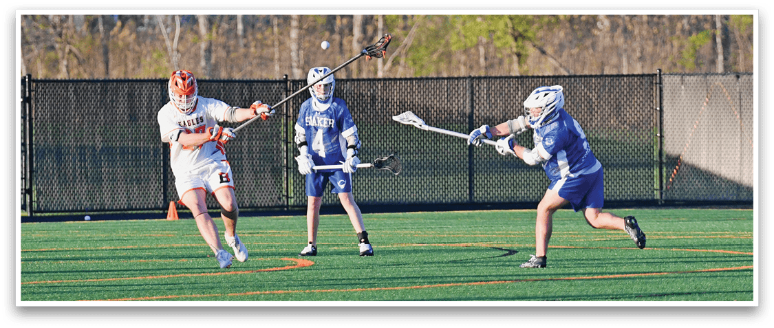 A man in a blue shirt is playing lacrosse. Description generated by AI