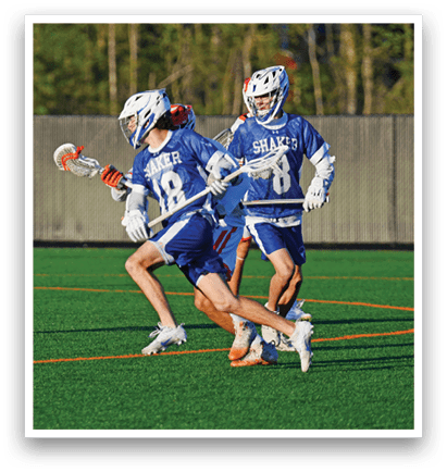 Two men playing lacrosse on a field. Description generated by AI