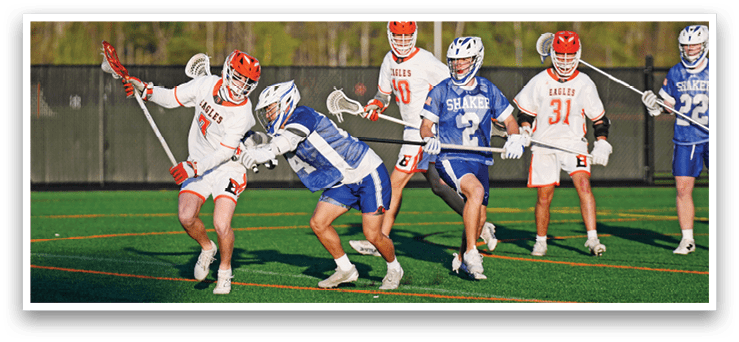 A group of men playing lacrosse on a field. Description generated by AI