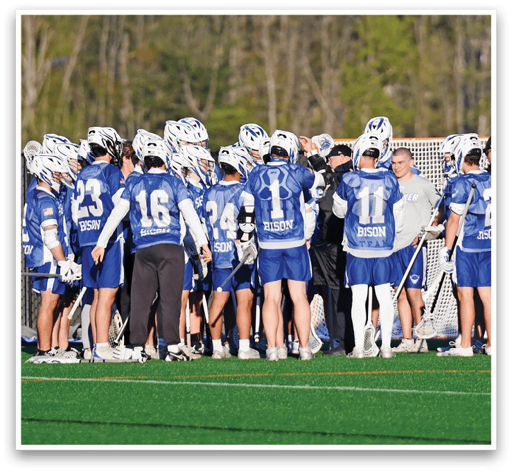 A group of people wearing blue and white uniforms are standing on a field. Description generated by AI