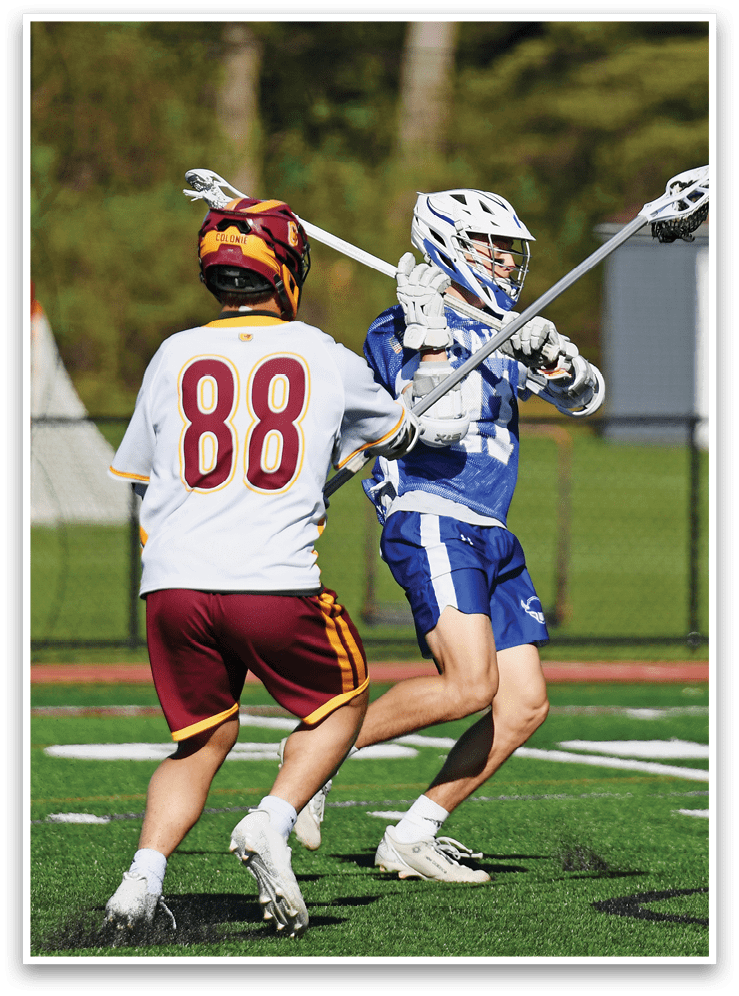 A group of men playing lacrosse on a field. Description generated by AI