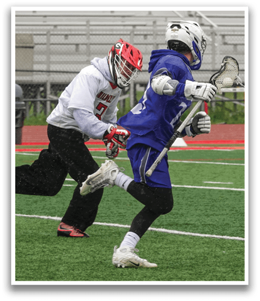 Two people playing lacrosse on a field. Description generated by AI
