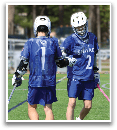 Two men wearing blue shirts and white pants are holding their hockey sticks. Description generated by AI