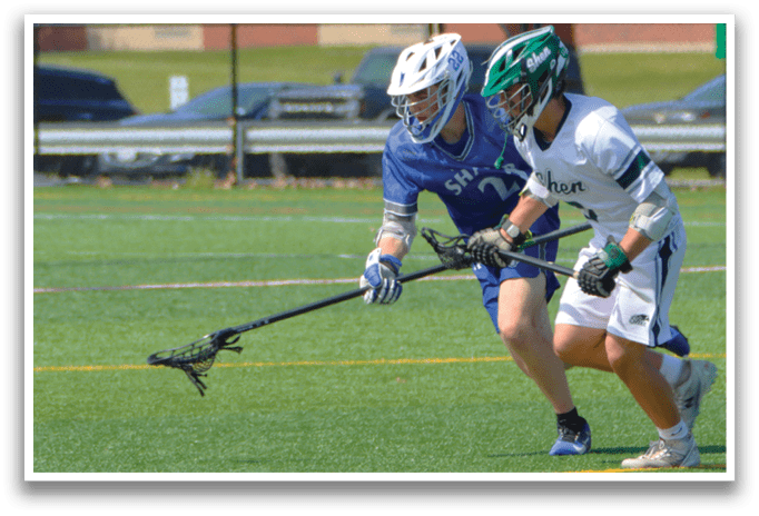 A man in a blue shirt and white shorts is playing lacrosse. Description generated by AI
