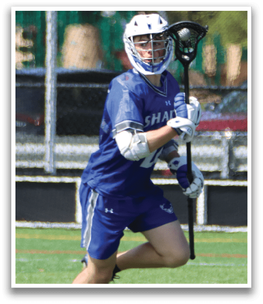 A man wearing blue shorts and a blue and white shirt is running with a black and white lacrosse stick. Description generated by AI