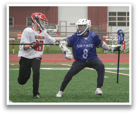 Two men playing lacrosse on a field. Description generated by AI