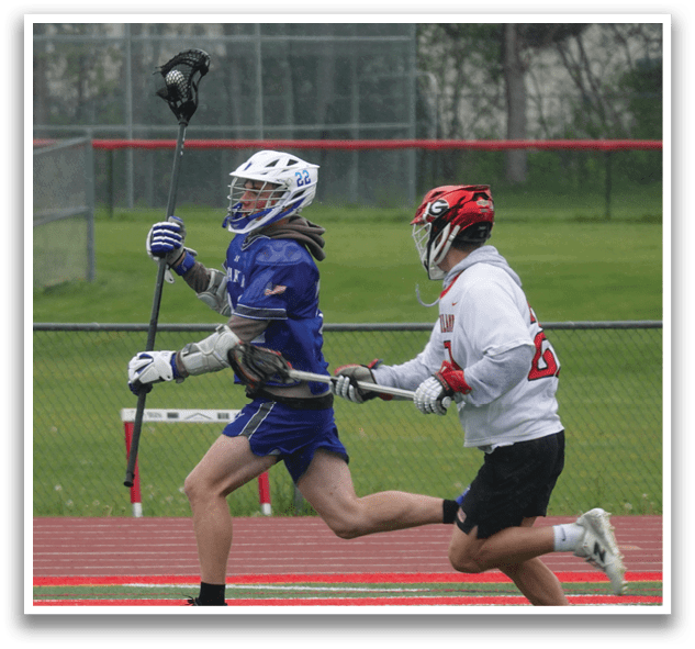 A man in a blue and white uniform is running with a lacrosse stick. Description generated by AI