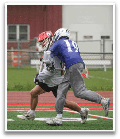 Two men playing a game of lacrosse. Description generated by AI