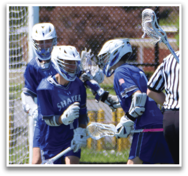 A group of young men playing lacrosse on a field. Description generated by AI