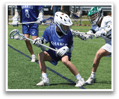 Two men playing lacrosse on a field. Description generated by AI
