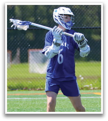 A man wearing a blue and white shirt and holding a lacrosse stick. Description generated by AI