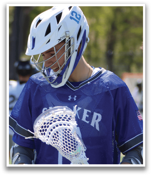 A young man wearing a blue and white shirt holding a lacrosse stick. Description generated by AI