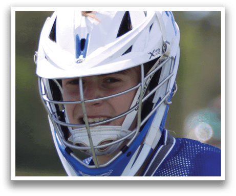 A young man wearing a blue and white hockey uniform and a helmet. Description generated by AI
