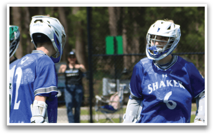 A group of young men playing a game of lacrosse. Description generated by AI