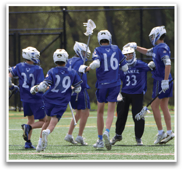 A group of young men playing lacrosse on a field. Description generated by AI