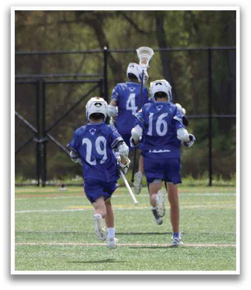A group of people wearing blue and white uniforms are playing a game of lacrosse. Description generated by AI