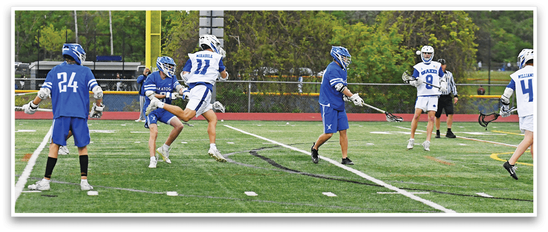 A group of people playing a game of lacrosse on a field. Description generated by AI