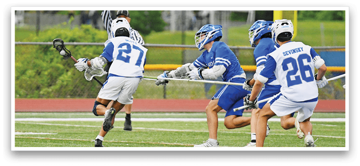 A group of men playing lacrosse on a field. Description generated by AI