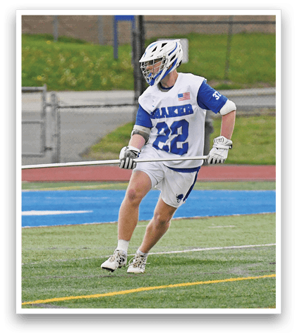Two men playing lacrosse on a field. Description generated by AI