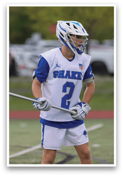 A boy wearing a blue and white jersey with the number 2 on it. Description generated by AI