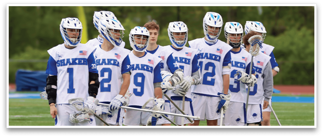 A group of young men wearing blue and white uniforms and holding lacrosse sticks. Description generated by AI