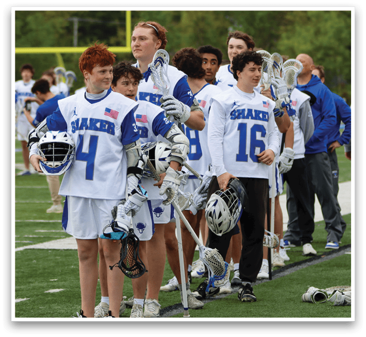 A group of people wearing white and blue shirts and holding lacrosse sticks. Description generated by AI