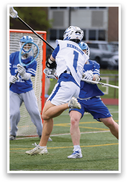 A group of men playing lacrosse on a field. Description generated by AI