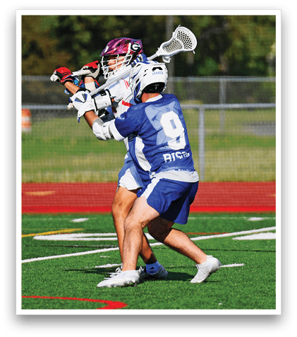 Two men playing lacrosse on a field. Description generated by AI