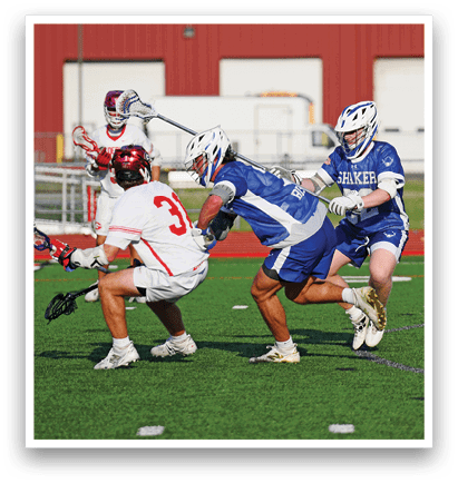 A group of men playing lacrosse on a field. Description generated by AI