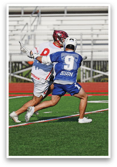 Two men playing football on a field. Description generated by AI