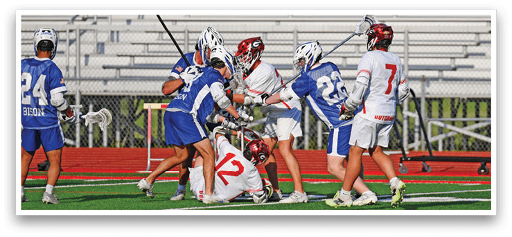 A group of people playing lacrosse on a field. Description generated by AI