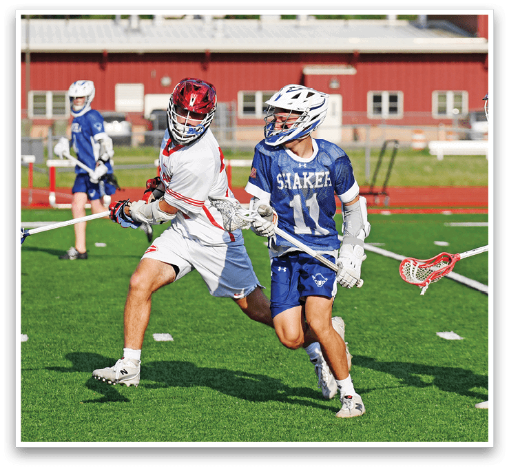 A group of people playing lacrosse on a field. Description generated by AI