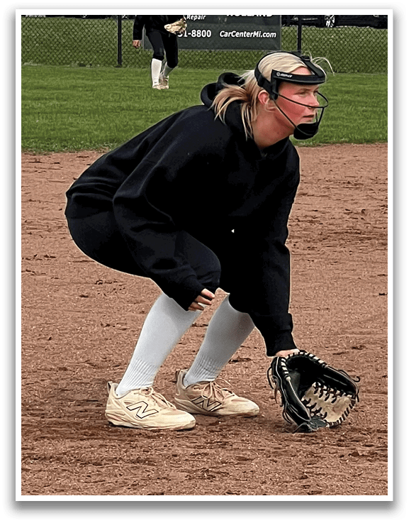 Two female softball players in black and white uniforms are on the field. One player is in the outfield, while the other is in the infield. They are both wearing gloves and are ready to catch the ball. AI generated content