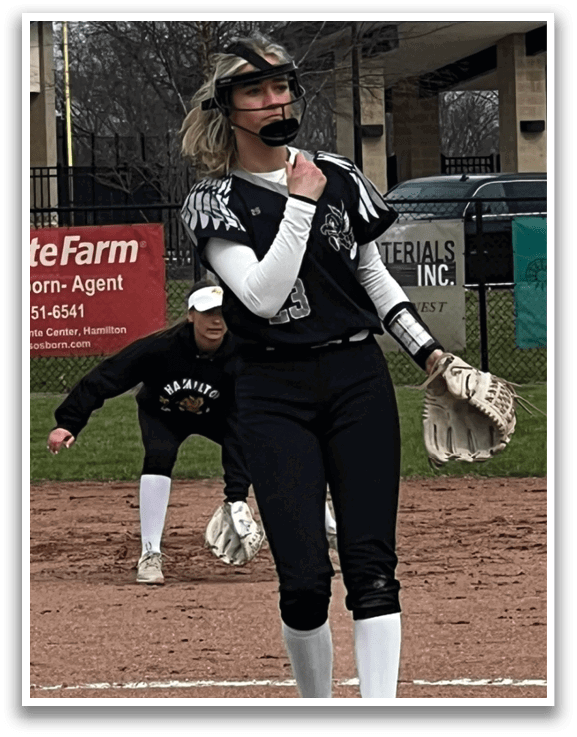 A female baseball player in a black and white uniform is standing on the field, holding a baseball glove. AI generated content