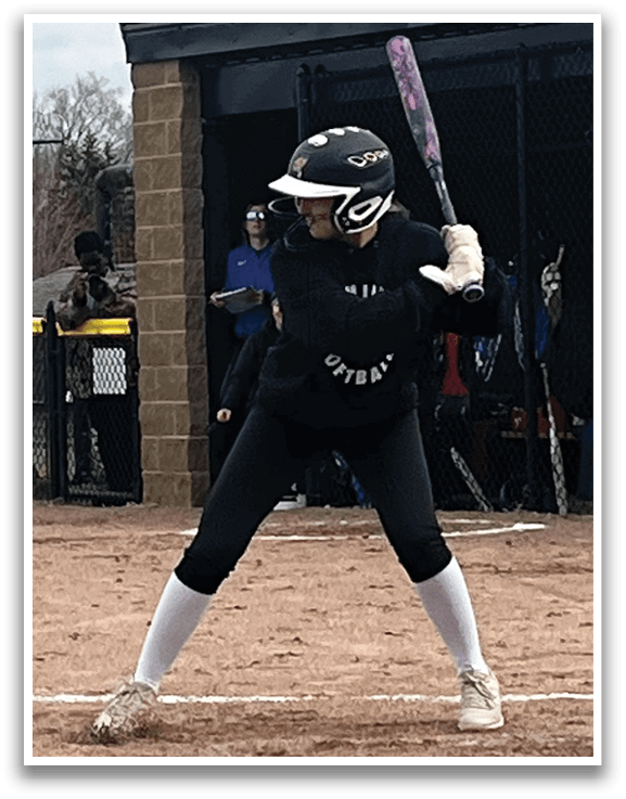 A female baseball player in a black shirt and white socks is swinging a bat at a ball. AI generated content