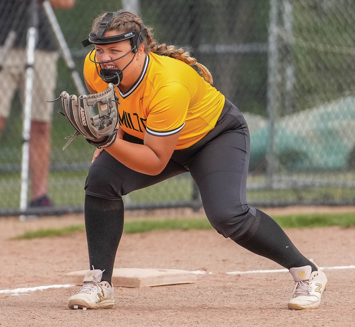 A female baseball player is in position, ready to catch a ball. AI generated content