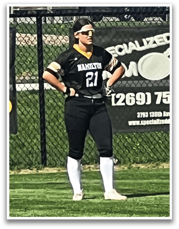 A woman wearing a black and yellow shirt stands on a grassy field. AI generated content