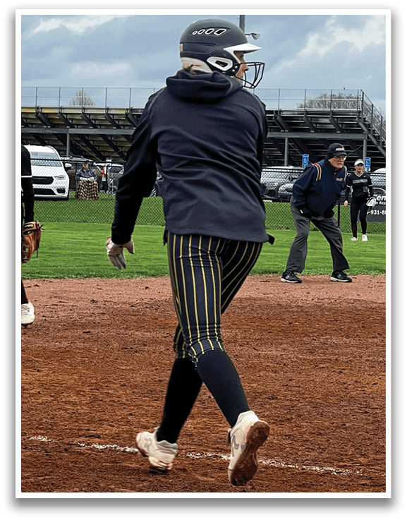Three female baseball players on a field. One player is running towards home plate. AI generated content
