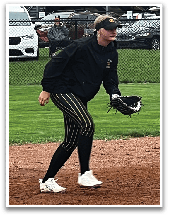 A woman wearing a black shirt and white shoes is standing on a baseball field. AI generated content