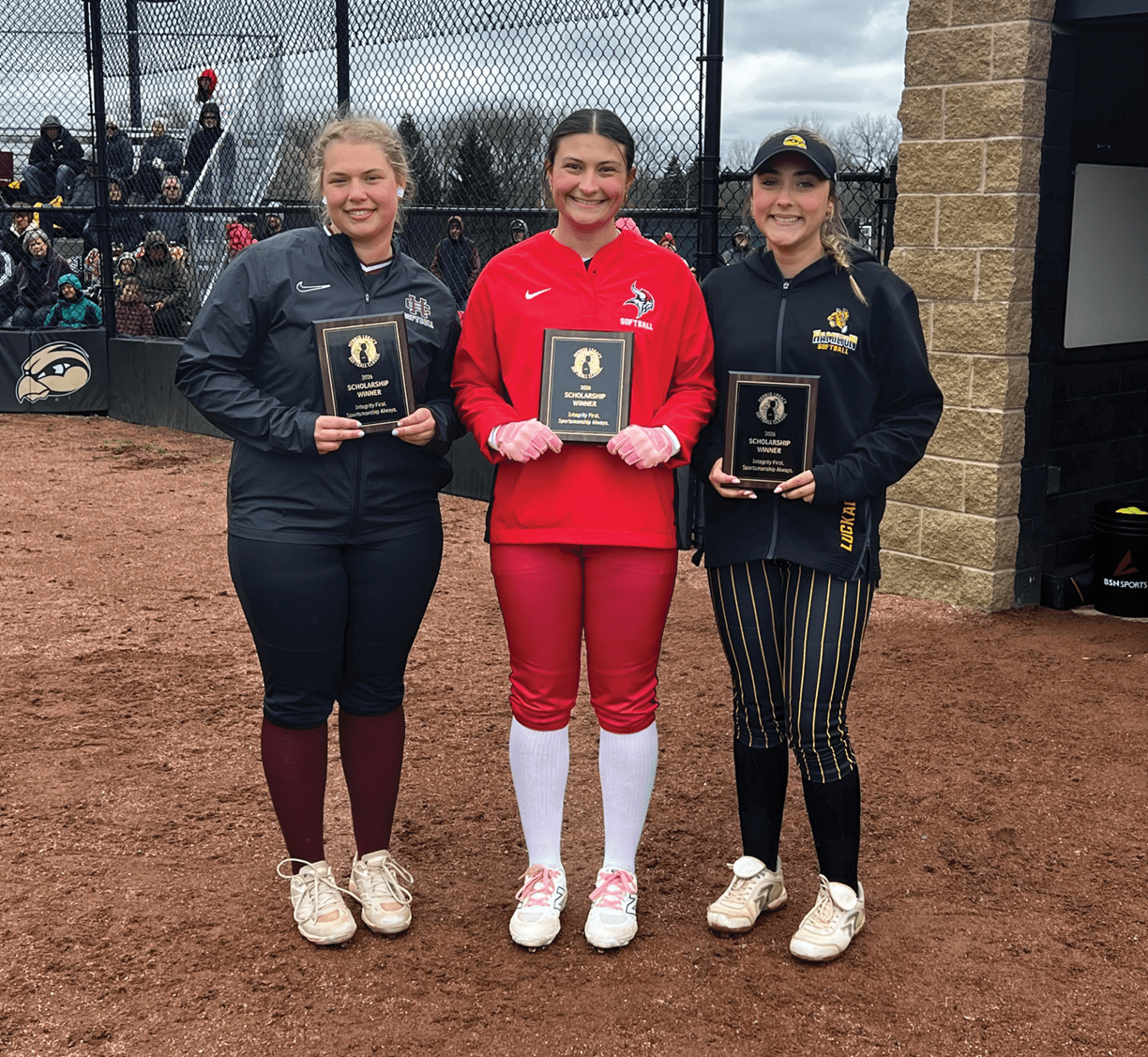 Three women are standing on a baseball field, holding trophies. AI generated content