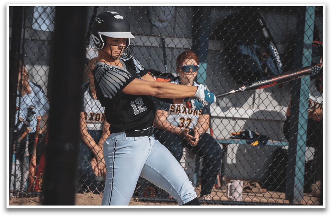 A woman is swinging a baseball bat. Description generated by AI