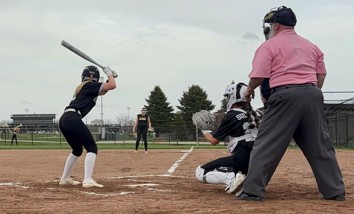 A baseball game is taking place with a batter holding a bat and a catcher wearing a baseball glove. Description generated by AI